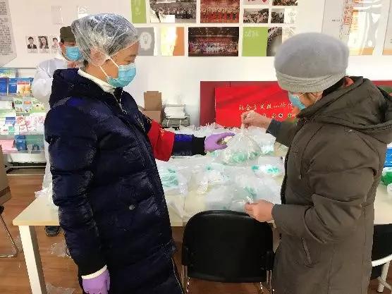 為樓棟分發(fā)口罩，并為包裝袋消毒